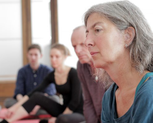 Übungsgruppe Do-In Trainerin Nina Langmeier erklärt und 4 TeilnehmerInnen hören zu